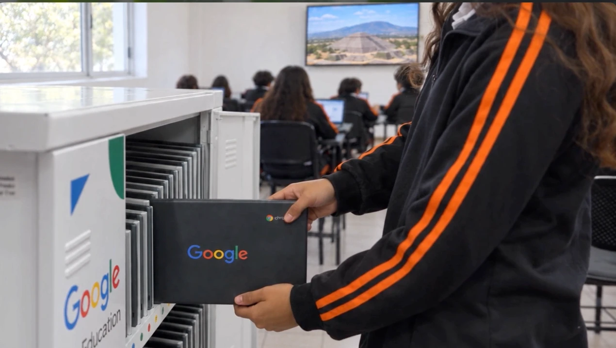 Una estudiante sostiene una Chromebook junto al gabinete abierto