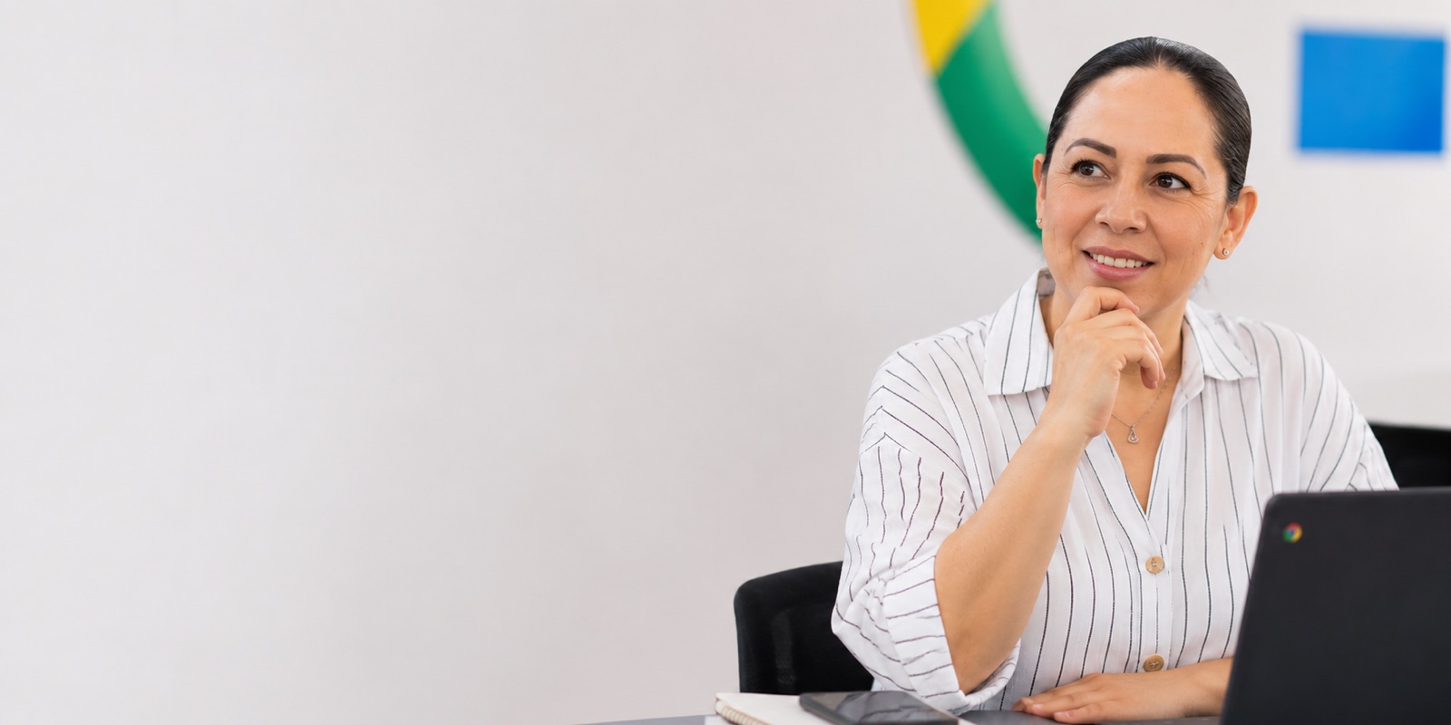 Docente reflexionando frente a su computadora portátil